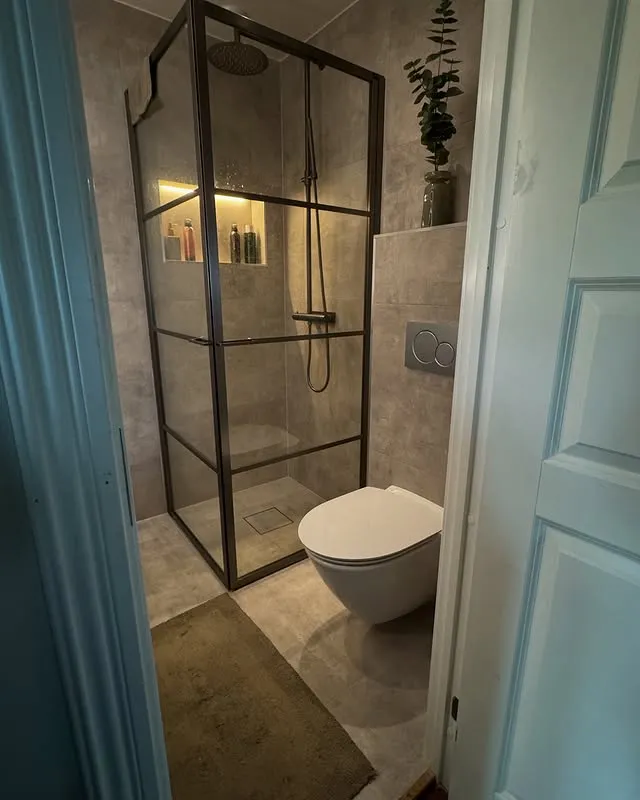 Badrumsrenovering Kalmar - Modern dusch med svart ram av NBOS AB